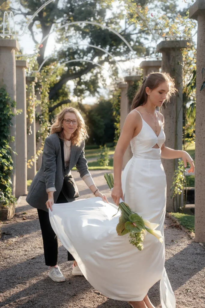 Letzte Anpassung am Brautkleid während eines Shootings im Freien