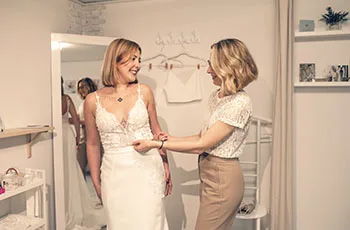 Irina passt einer Braut das Kleid bei der Anprobe im Atelier an