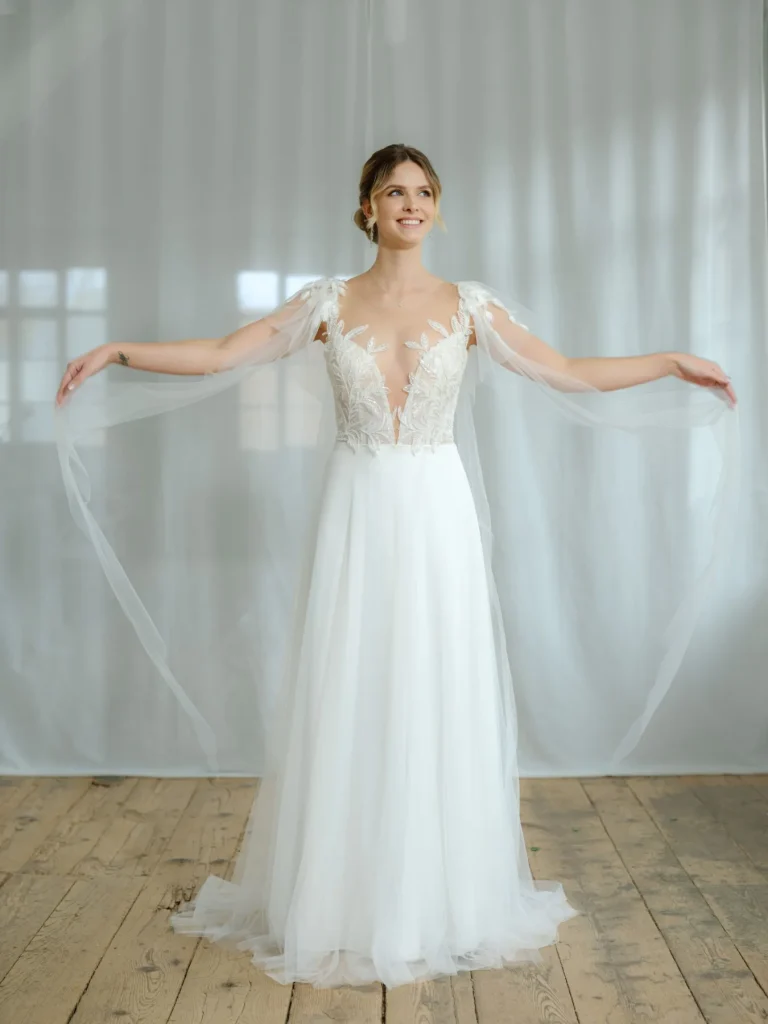 Braut in einem Brautkleid mit zarten Ärmeln aus Tüll