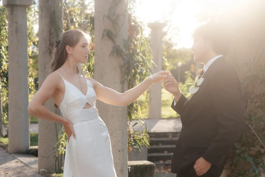 Brautpaar tanzt zwischen Säulen, die Braut im Fit-and-Flare-Kleid